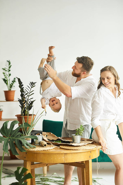 Happy family working at home. Transplanting plants with their child - Photo, image