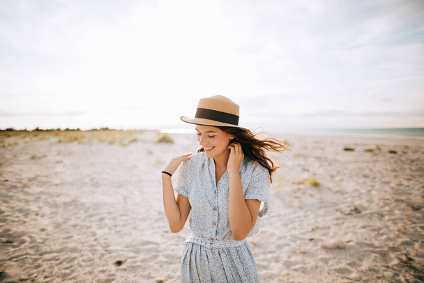 Young beautiful girl in a hat on the beach - Foto, Bild