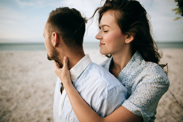 Kochająca młoda para przytulająca się i całująca na plaży morskiej. Pojęcie miłości - Zdjęcie, obraz
