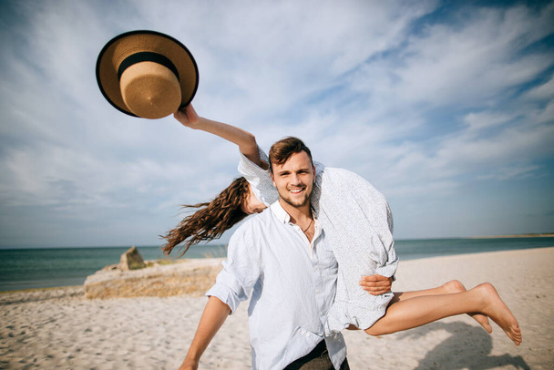 Liebendes, glückliches junges Paar, das am Strand spaziert. Sommerferien - Foto, Bild