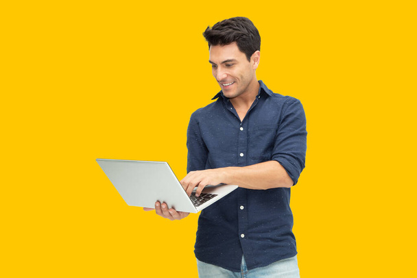Retrato de um homem animado segurando computador portátil isolado em fundo amarelo, Sentindo felicidade, Modelo Masculino Caucasiano
 - Foto, Imagem