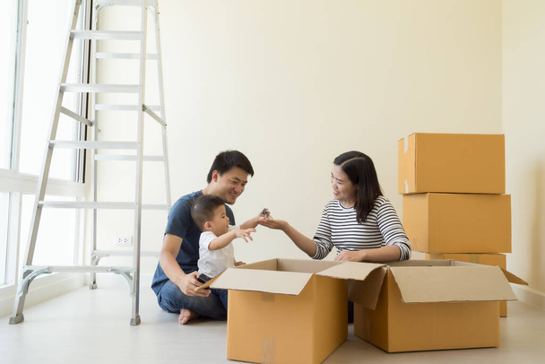Szczęśliwa azjatycka rodzina z kartonowymi pudełkami w nowym domu w dniu przeprowadzki, Nieruchomości i koncepcji domu - Zdjęcie, obraz
