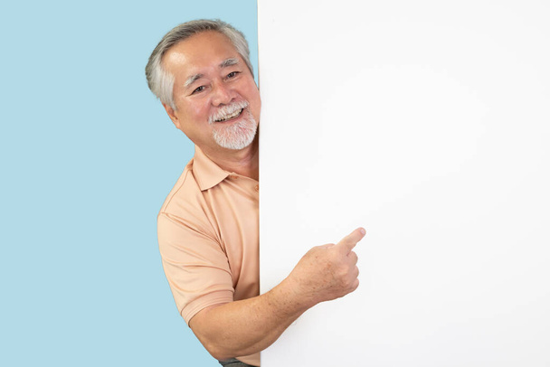 glimlachende aziatische senior man wijzend naar iets - Foto, afbeelding