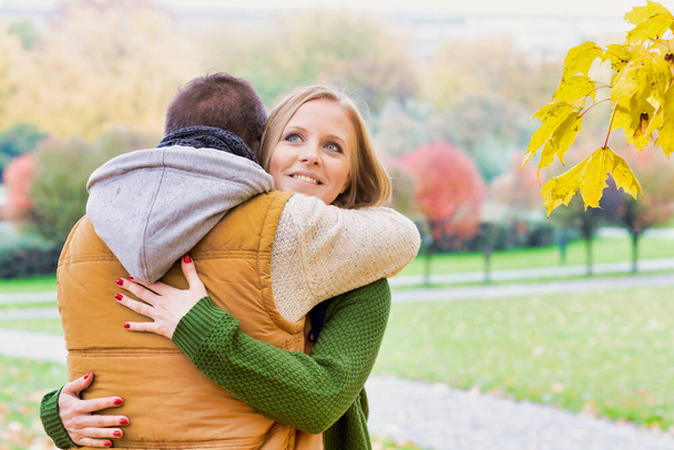 Portrait of man embracing his beautiful wife in park - Photo, image