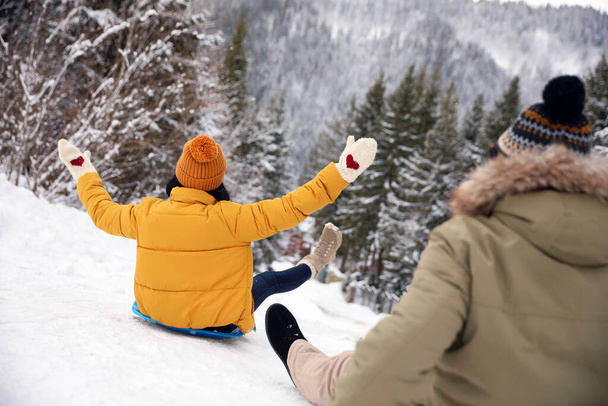 雪の上で楽しさとそりを持っているカップル。冬休み - 写真・画像