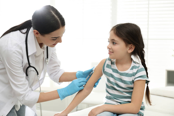 Doctor vaccinating little child in modern clinic - Zdjęcie, obraz