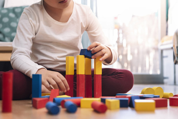 unrecognizable kid playing at home with building blocks, concept of indoor leisure for children - Φωτογραφία, εικόνα
