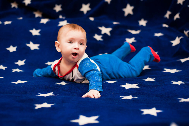 petit garçon se trouve sur un fond bleu avec des étoiles
 - Photo, image