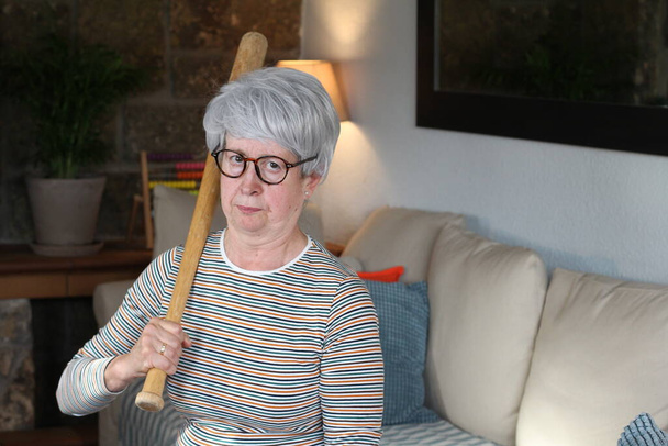 Старшая женщина с бейсбольной битой
 - Фото, изображение
