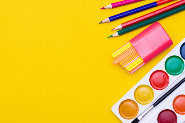 Office supplies on a yellow background. Various school supplies on a bright yellow background. Text frame with office supplies. The layout of the school. Welcome back to school. Concept of advertising office supplies. Flat lay with space for text. - Photo, image