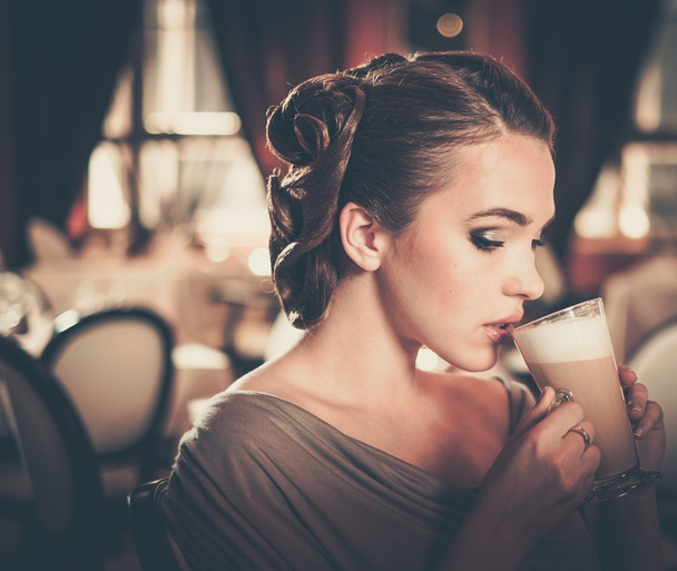 Belle jeune fille avec tasse de café seule dans un restaurant
 - Photo, image