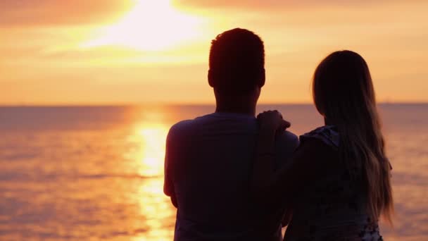 Πολυεθνικό ερωτευμένο ζευγάρι θαυμάζει το ηλιοβασίλεμα πάνω από τον ωκεανό - Πλάνα, βίντεο