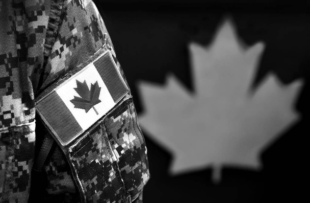 Canada Day. Flag of Canada on the military uniform and red Maple leaf on the background. Canadian soldiers. Army of Canada. Canada leaf. Remembrance Day. Poppy day.  - Foto, Bild