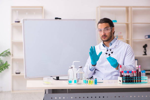 Молодой химик, работающий в лаборатории - Фото, изображение