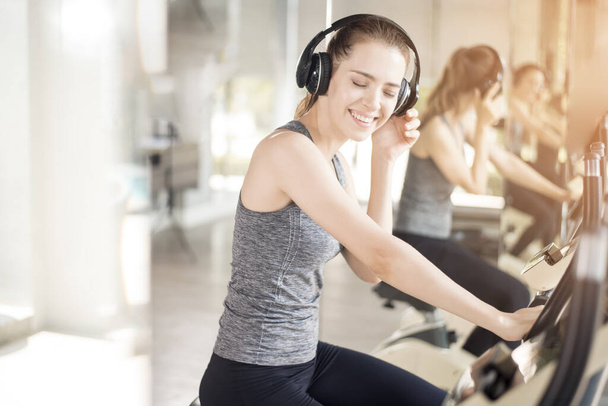 Pretty young sport woman is exercise on bicycle in gym, Healthy lifestyle  - Fotó, kép