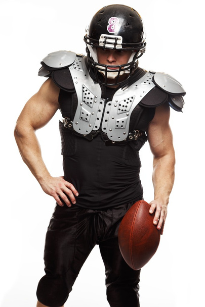 Американський футболіст з м'ячем у шоломі і захисних щитах. - Фото, зображення