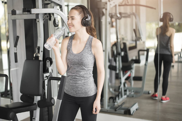 Pretty young sport woman is drinking water  in gym, Healthy lifestyle  - Zdjęcie, obraz