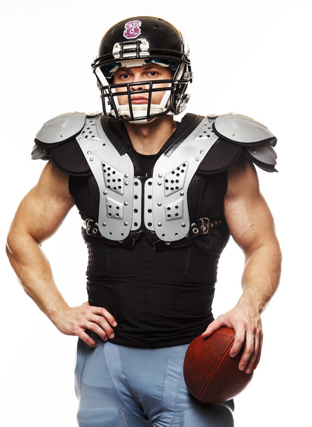 American football player with ball wearing helmet and protective shields - Фото, изображение