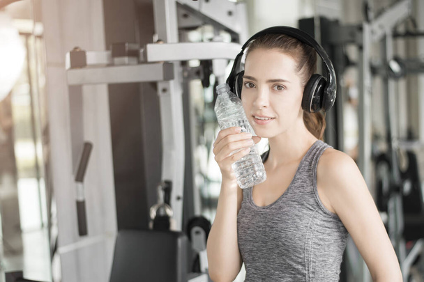 Pretty young sport woman is drinking water  in gym, Healthy lifestyle  - Fotoğraf, Görsel