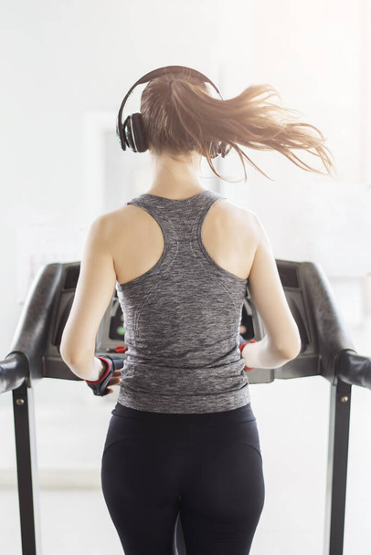 Back sport woman jogging on treadmill in gym, Healthy lifestyle  - Photo, image