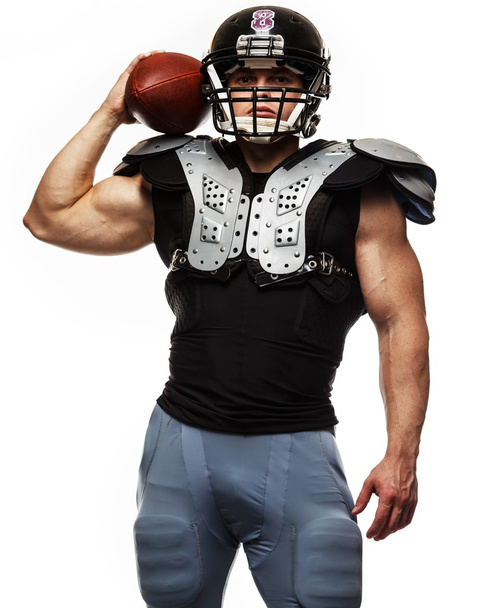 Amerikkalainen jalkapalloilija pallo yllään kypärä ja suojakilvet - Valokuva, kuva