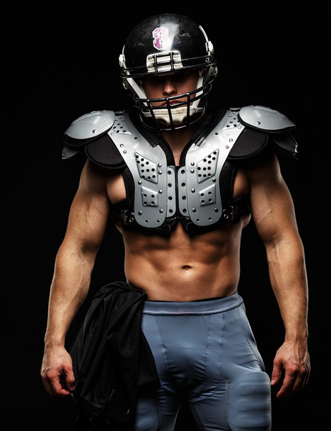 American football player wearing helmet and protective armour - Foto, immagini