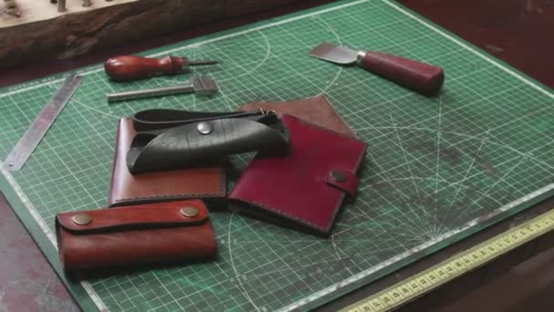 Finished handmade leather wallets keyholders on tanners table - Footage, Video