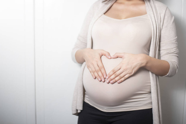 Закрыть беременную женщину, ожидающую ребенка
 - Фото, изображение