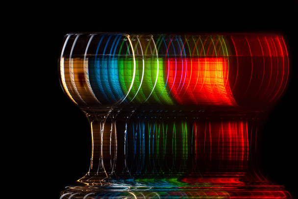 moving glass changing color on a black background, blur and strobe - Foto, Bild