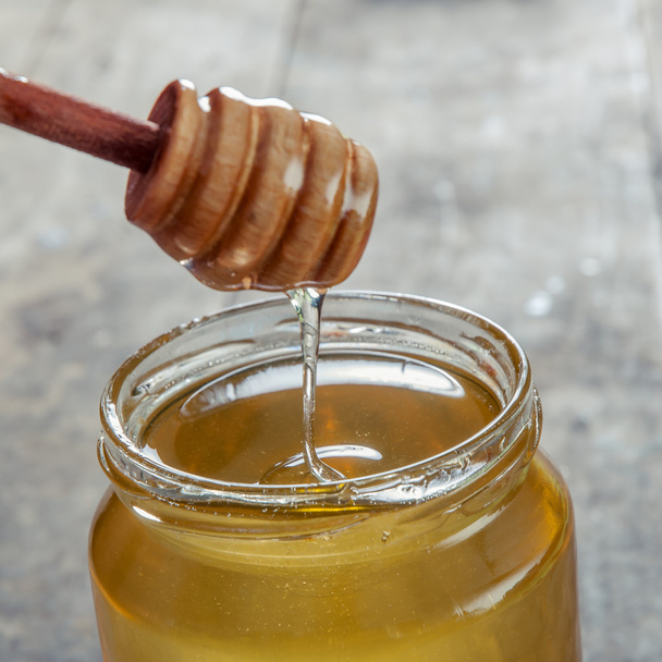 Tarro de miel de vidrio con cazo
 - Foto, Imagen
