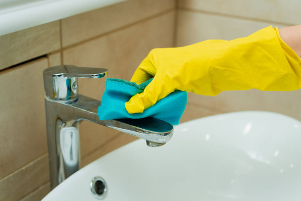 Someone is washing a sink with sponge. Someone is washing a sink in yellow gloves. - Foto, immagini