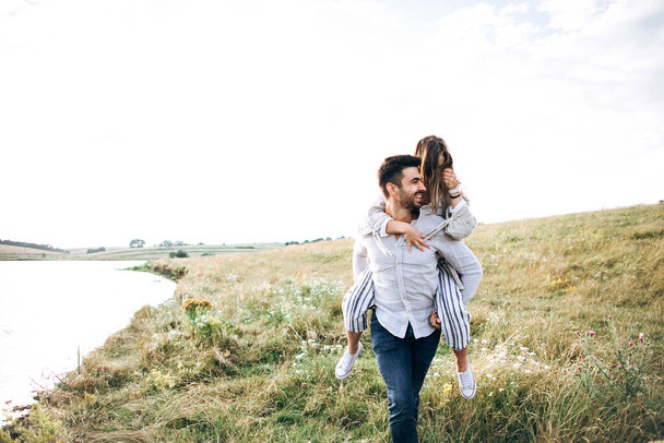 楽しさ、抱きしめ、フィールドの空の背景に笑顔を持つ美しい愛情のあるカップル。男と女の子のヒップスター旅行 - 写真・画像