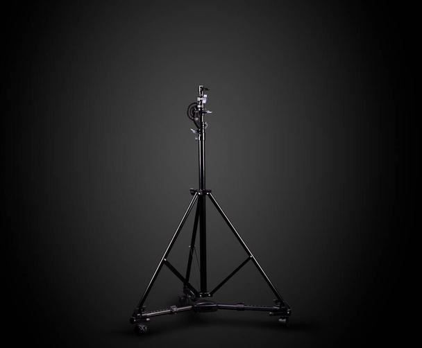 Studio lighting stands isolated on the black background with clipping path. Elements of professional photography equipment. - Photo, Image