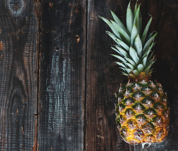 Fresh ripe pineapple on a wooden background with place for your text. - Foto, imagen