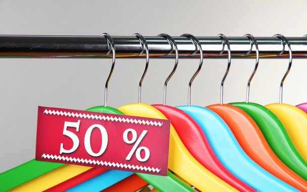 Wooden clothes hangers as sale symbol on gray background - Fotografie, Obrázek