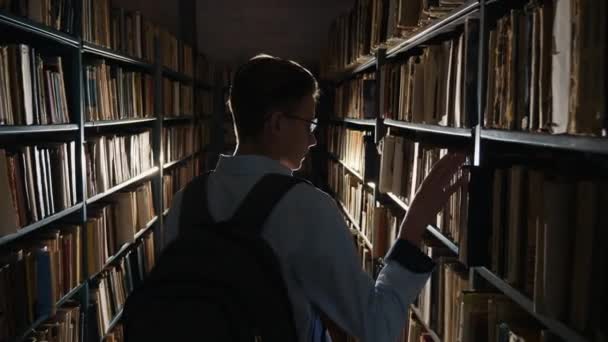 Ein männlicher Student auf der Suche nach einem Buch - Filmmaterial, Video