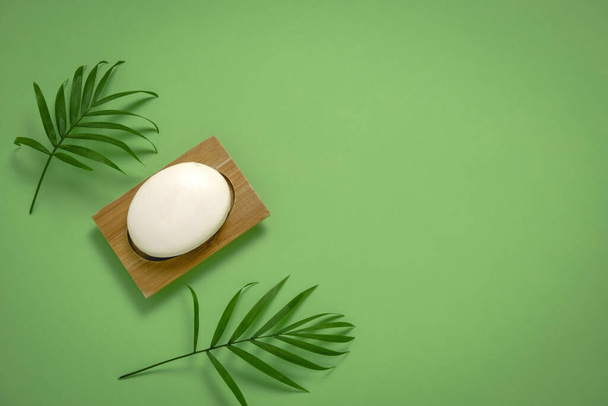 top view flat lay spoon and palm leaves on a green background copy space - Фото, зображення