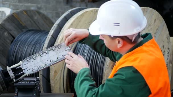 A communications engineer works with an optical fiber cable. - Footage, Video