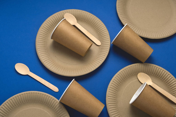 jednorazowy papier i drewno biodegradowalne zastawy stołowe na niebieskim tle, ekologiczny styl życia koncepcji - Zdjęcie, obraz