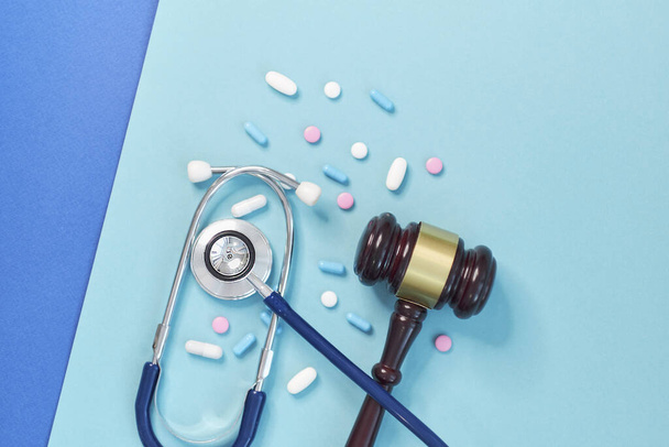 martelletto marrone e uno stetoscopio medico su sfondo blu. foto simbolo per errore e errore medico
 - Foto, immagini