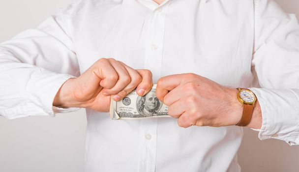 Un homme d'affaires déchire un billet en dollar. Concept de crise financière
. - Photo, image