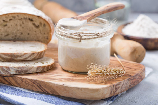 パンの葉は活発です。スターター生地(パン焼きのためのリーブンとして使用する水と小麦粉の発酵混合物) 。健康的な食事の概念 - 写真・画像