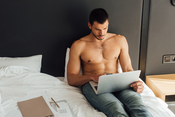 bearded and shirtless freelancer using laptop in bedroom  - Photo, Image
