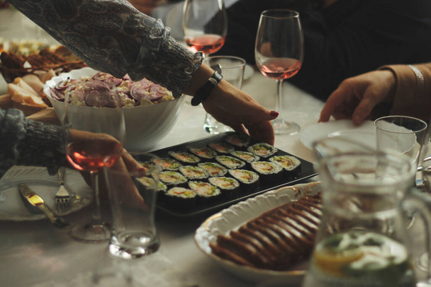 Mãos de mulher com sushi, derramando champanhe em vidro
 - Foto, Imagem