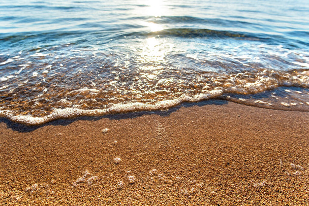 Закрытие небольших морских волн с прозрачной голубой водой над пляжем с желтым песком на летнем солнечном берегу. - Фото, изображение