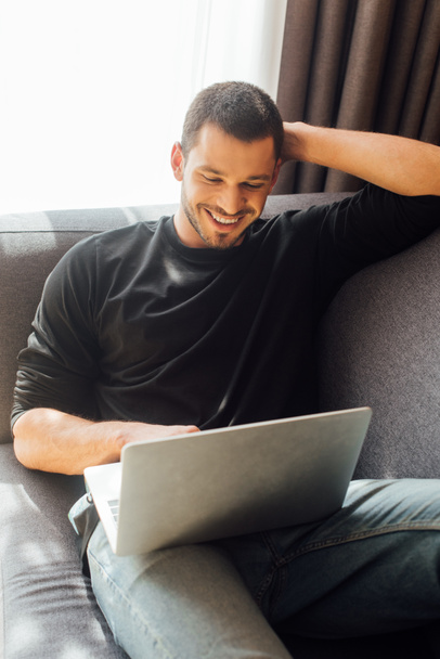 bearded and happy freelancer using laptop at home  - Valokuva, kuva