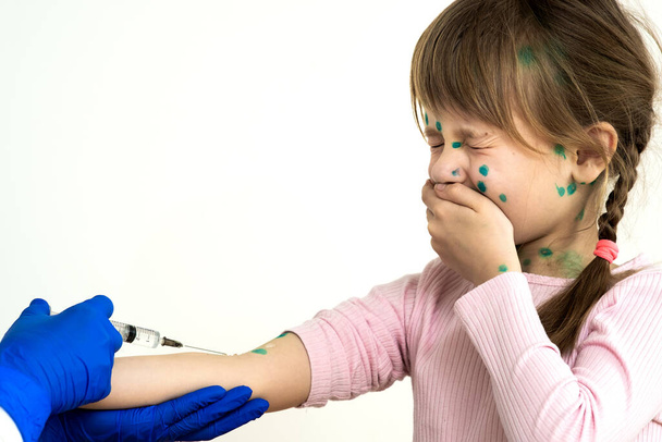 Médico haciendo la inyección de vacunación a una niña asustada enferma de varicela, sarampión o rubéola. Vacunación de los niños en el concepto escolar. - Foto, imagen