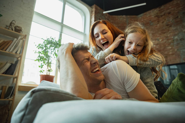 Family spending nice time together at home, looks happy and cheerful, lying down together - Photo, Image