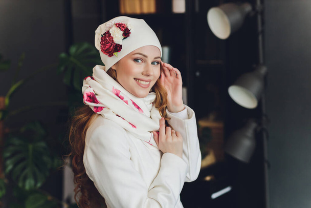 Surprised happy beautiful woman looking sideways in excitement. Christmas girl wearing knitted warm hat and mittens, isolated on gray background. - Foto, afbeelding