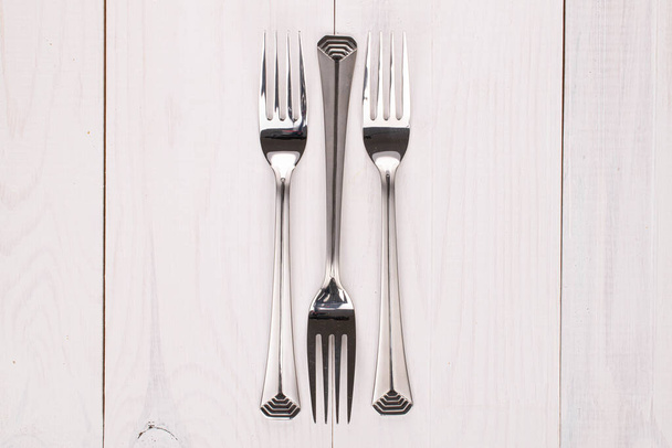 Group of three whole steel fork on white wood - Foto, imagen